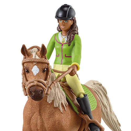 Close-up van de Schleich speelgoedfiguur van Sarah op het bruine paard Mystery.