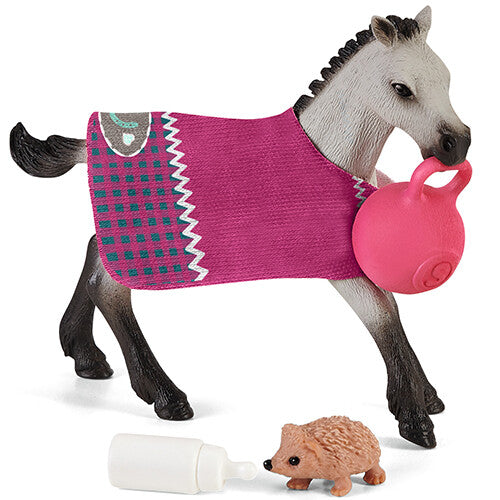 Schleich speelset met een grijs veulen met roze deken, een roze bal, een egel en een flesje.