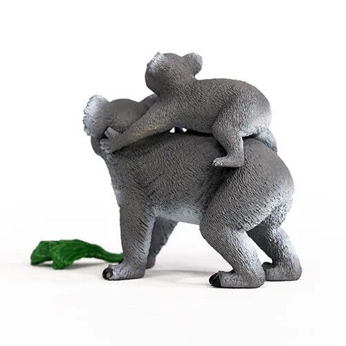 Schleich dierenfiguurtje van een koalabeer met een jong op de rug, van achteren gezien, met een groen blad.