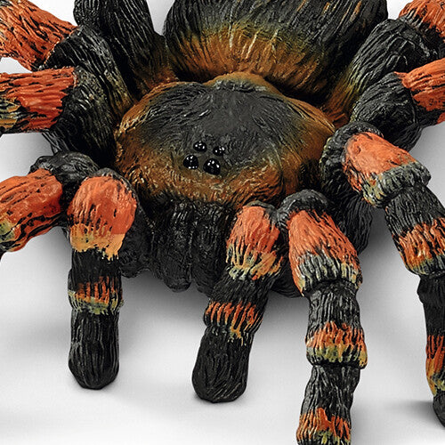 Detailopname van de zwarte en oranje vogelspin speelgoedfiguur.