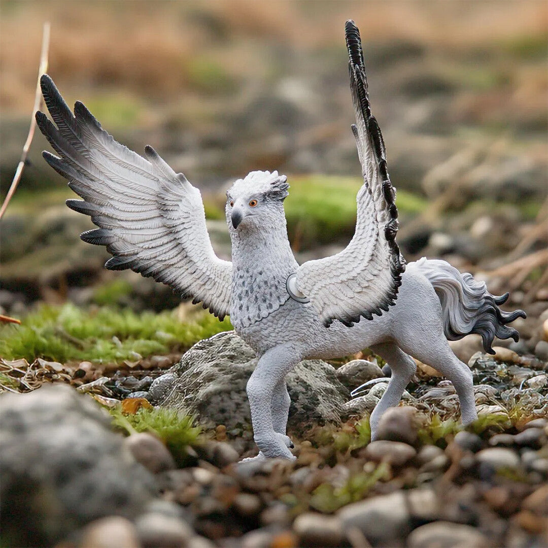 Schleich dierenfiguurtje van Scheurbek staand op rotsachtige grond met opgetilde vleugels.