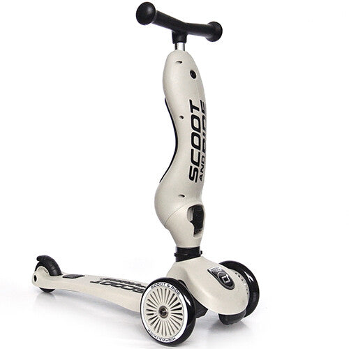Een beige Scoot & Ride 2-in-1 loopfiets met step in de stepstand op een witte achtergrond.