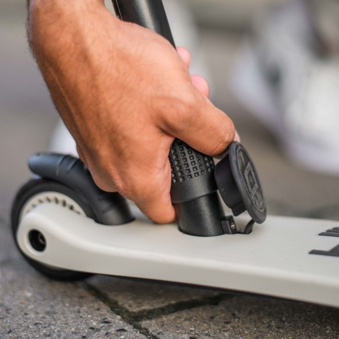 Een hand die een detail van de grijze Scoot & Ride 2-in-1 step of loopfiets aanpast.