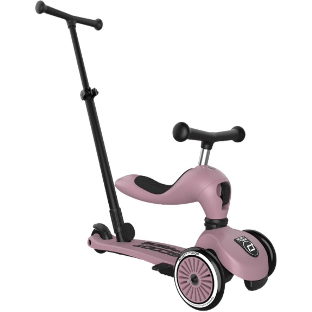 De roze Scoot & Ride 2-in-1 loopfiets in zitstand met duwstang, op een witte achtergrond.