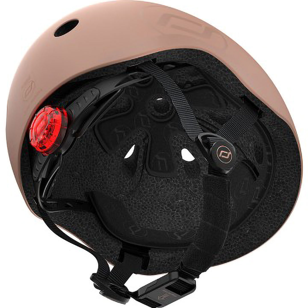 Binnenkant van de Scoot & Ride kinderhelm in beige kleur, met zicht op de zwarte voering en het rode achterlicht.