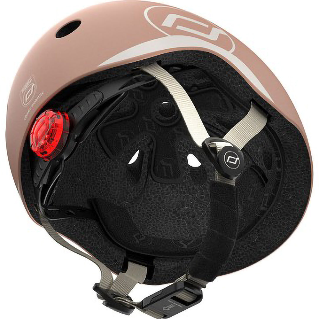 Binnenkant van de Scoot & Ride kinderhelm in beige kleur, met zwarte voering, bandjes en rood achterlicht.