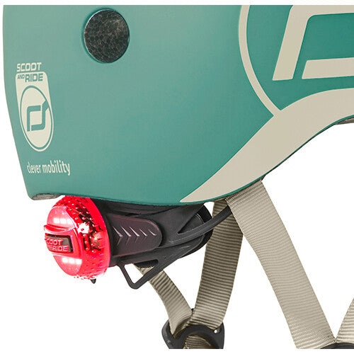 Detail van de zijkant van de groene Scoot & Ride kinderhelm met het rode achterlicht en logo.