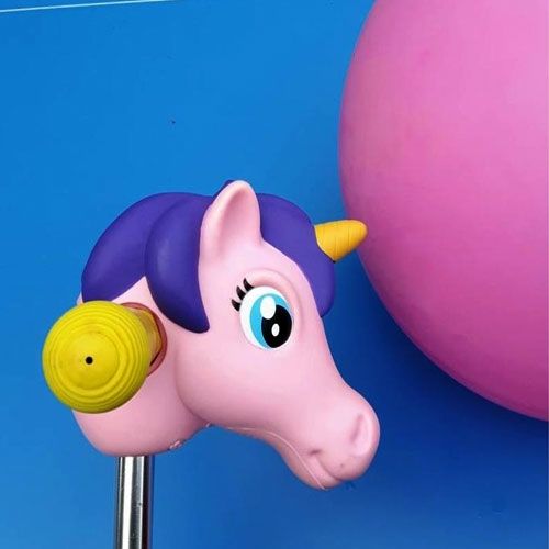 Scootaheadz kinderstep accessoire, een roze eenhoornhoofd met gele handgreep, voor een blauwe achtergrond met roze ballon.