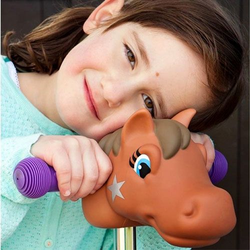 Een lachend meisje met haar hoofd op een Scootaheadz bruin ponyhoofd kinderstep accessoire met paarse handvatten.