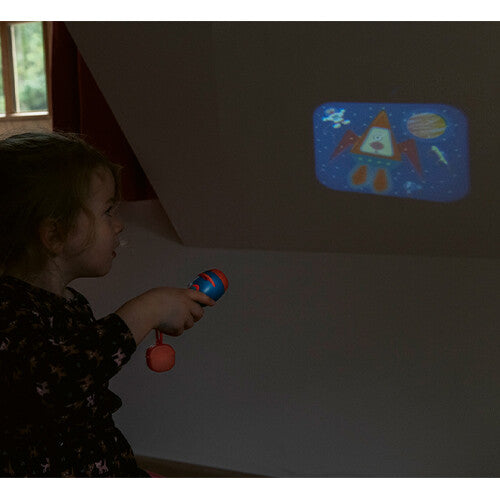 Een kind projecteert een kleurrijke ruimte-afbeelding op de muur met de Scratch Europe projectiezaklamp.