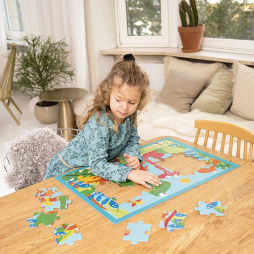 Een kind legt een dinosaurus legpuzzel op een houten tafel.
