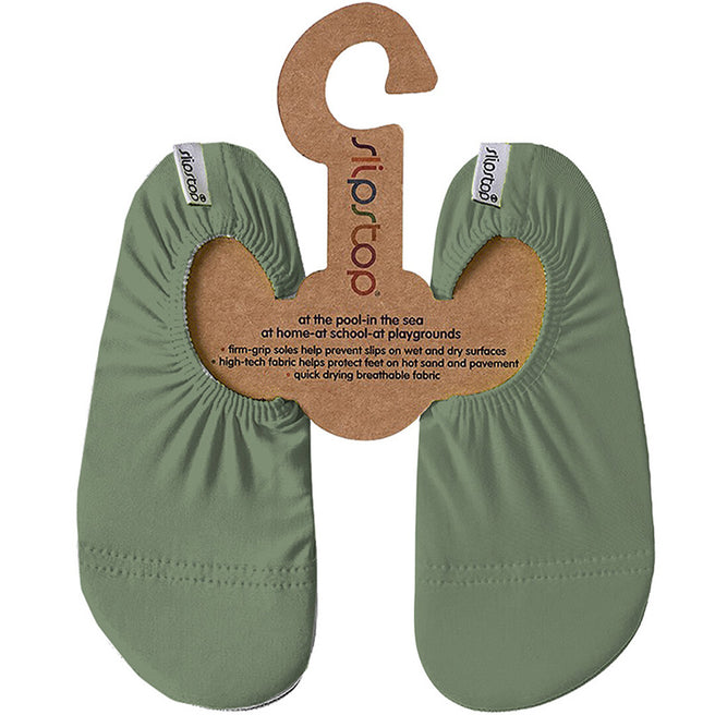 Groene Slipstop kinderschoenen op een kartonnen hanger met productinformatie.