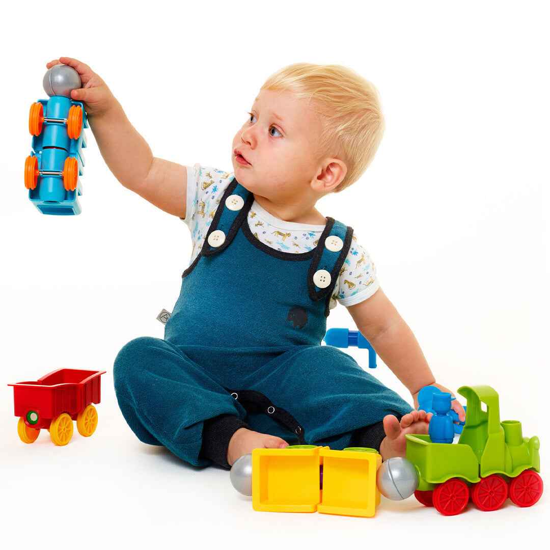 Een baby speelt met de SmartMax magnetische trein en bouwt met de blauwe onderdelen.