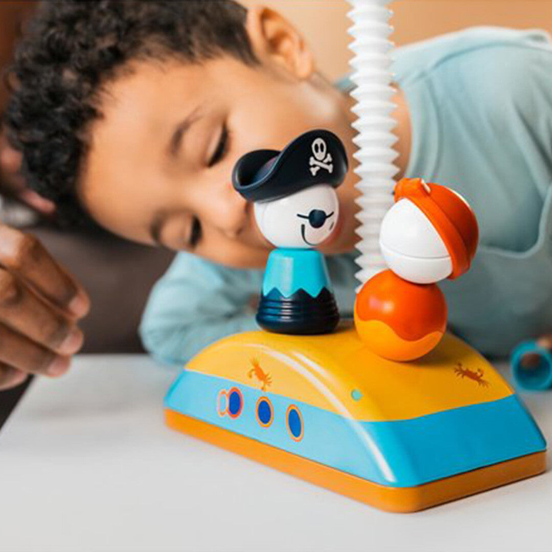 Een kind speelt met het SmartMax My First Piraten magnetisch puzzelspel, waarbij twee piratenfiguren op een eilandje staan.