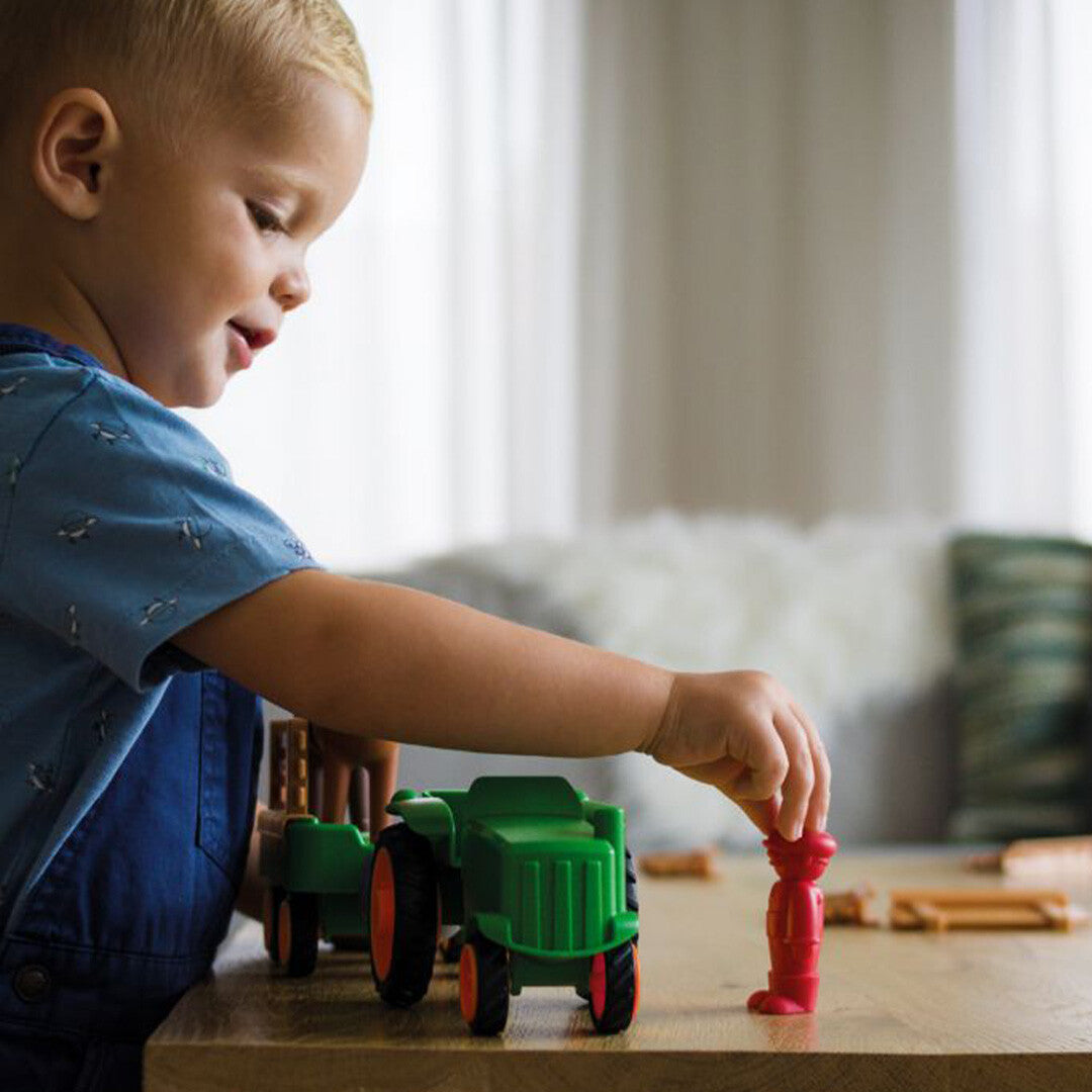 Een jongen speelt aan tafel met de Smartmax My First Tractor Set en plaatst de boerfiguur.