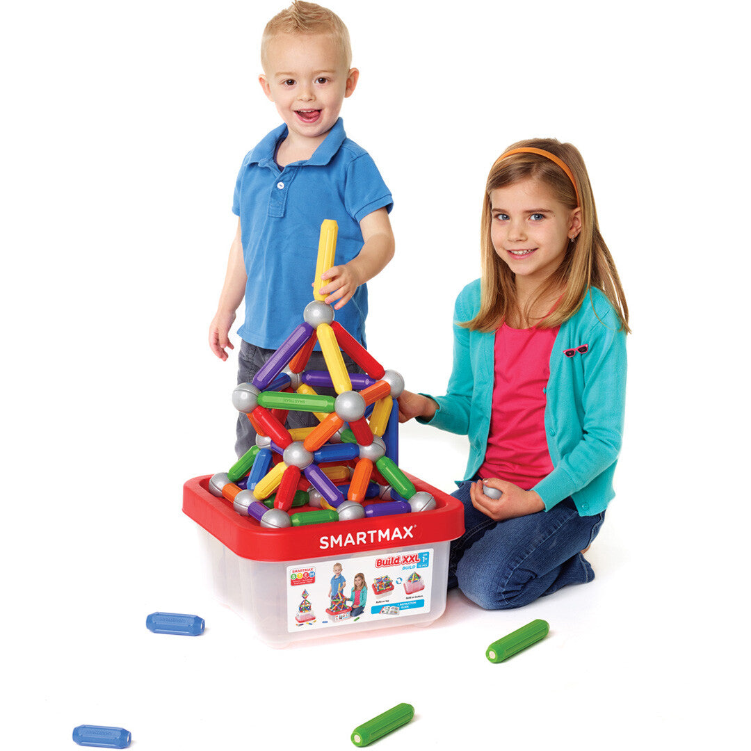 Twee kinderen spelen met de SmartMax magnetische bouwset, waarbij ze een kleurrijke constructie bouwen op de opbergdoos.