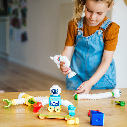 Een kind speelt met de SmartMax magnetische bouwset en houdt een flexibel onderdeel vast.