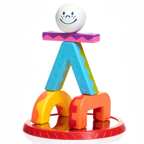 Een Smartmax acrobaatfiguur opgebouwd uit kleurrijke magnetische stukken en een bal met een gezichtje, staand op een spiegelende rode basis.