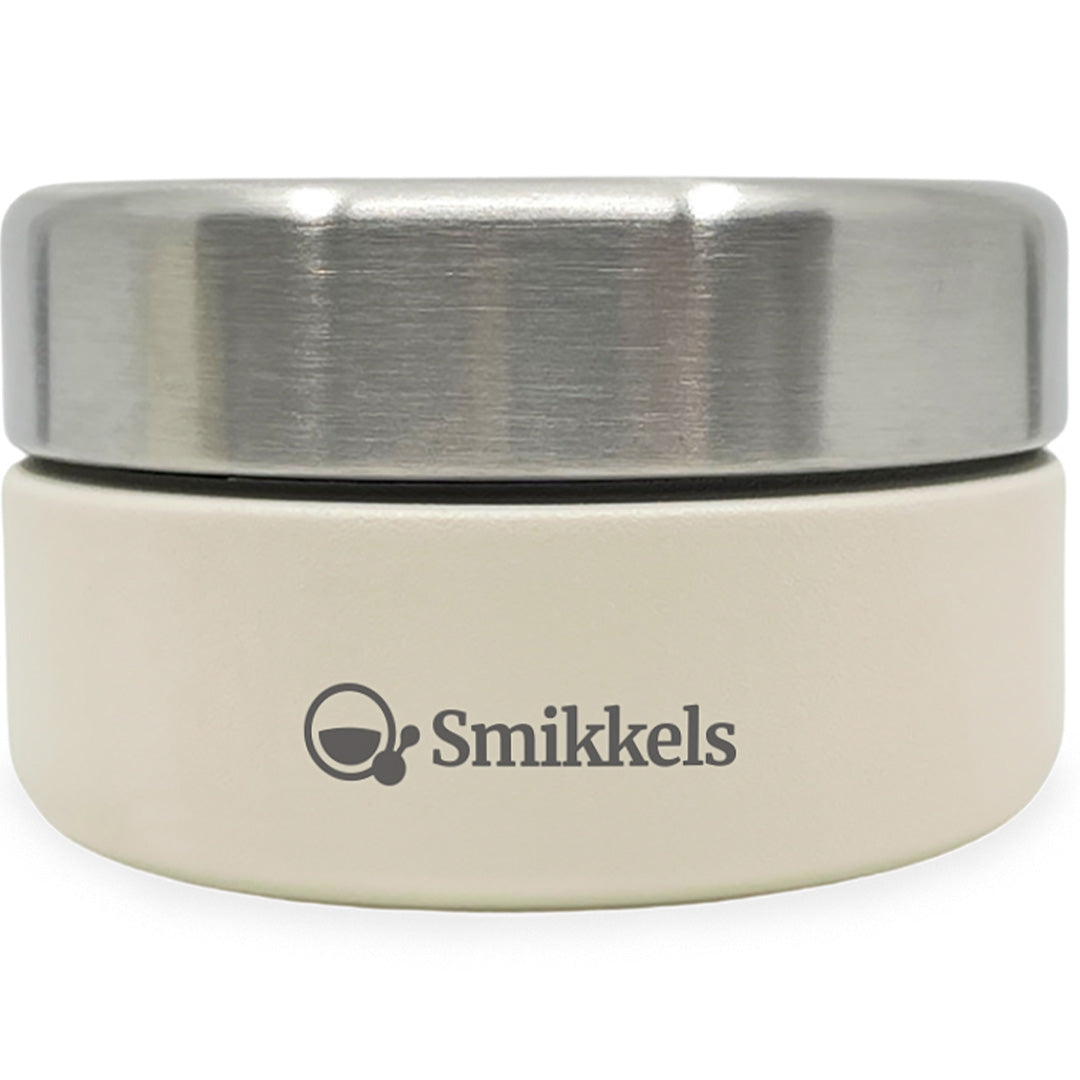 Smikkels rvs voedselpot crème met zilverkleurig deksel en logo.