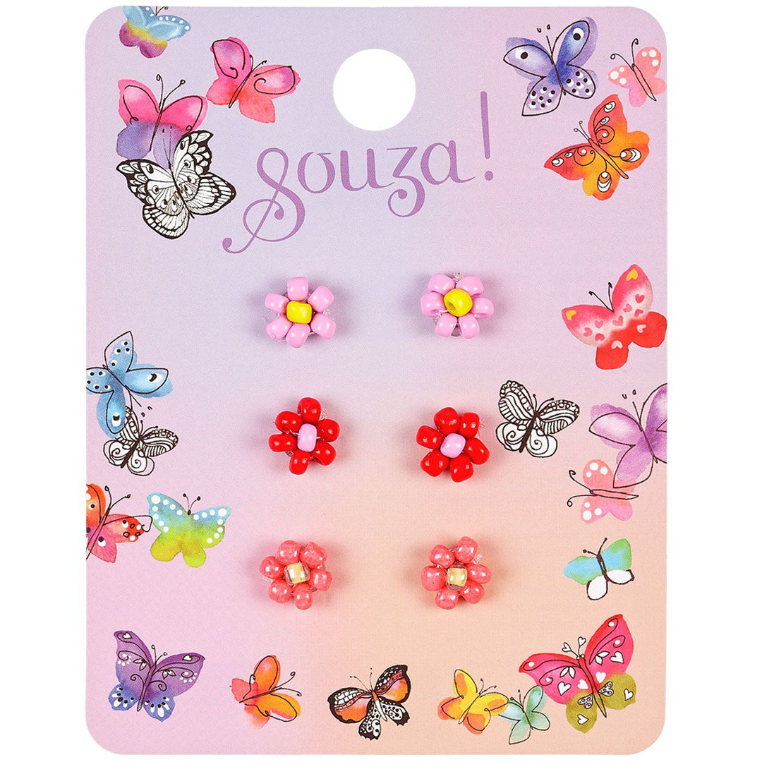 Souza for kids verpakking met drie paar bloemvormige kinder oorbellen in roze en rode tinten.