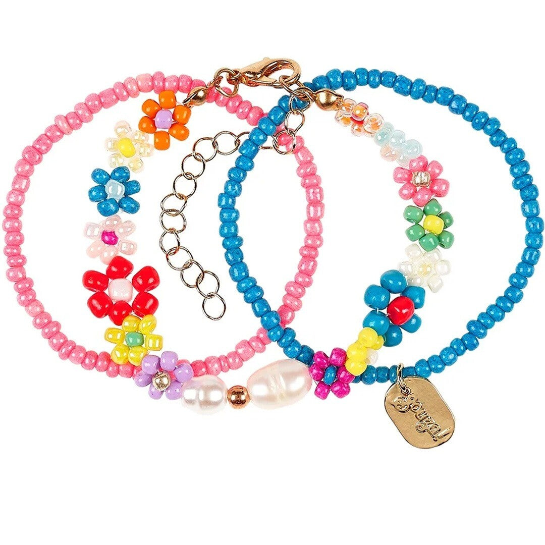 Drie Souza for Kids kinderarmbanden met kralen en bloemmotieven, waarvan één met parels.