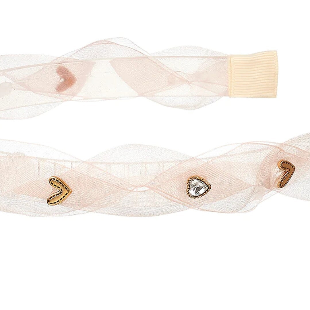 Detailfoto van de roze kinderhoofdband met hartjesdecoraties.