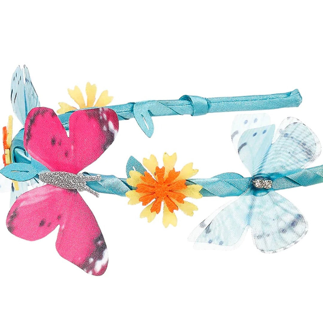 Detailopname van de kinder hoofdband met een roze en een lichtblauwe vlinder en bloemen op de blauwe band.
