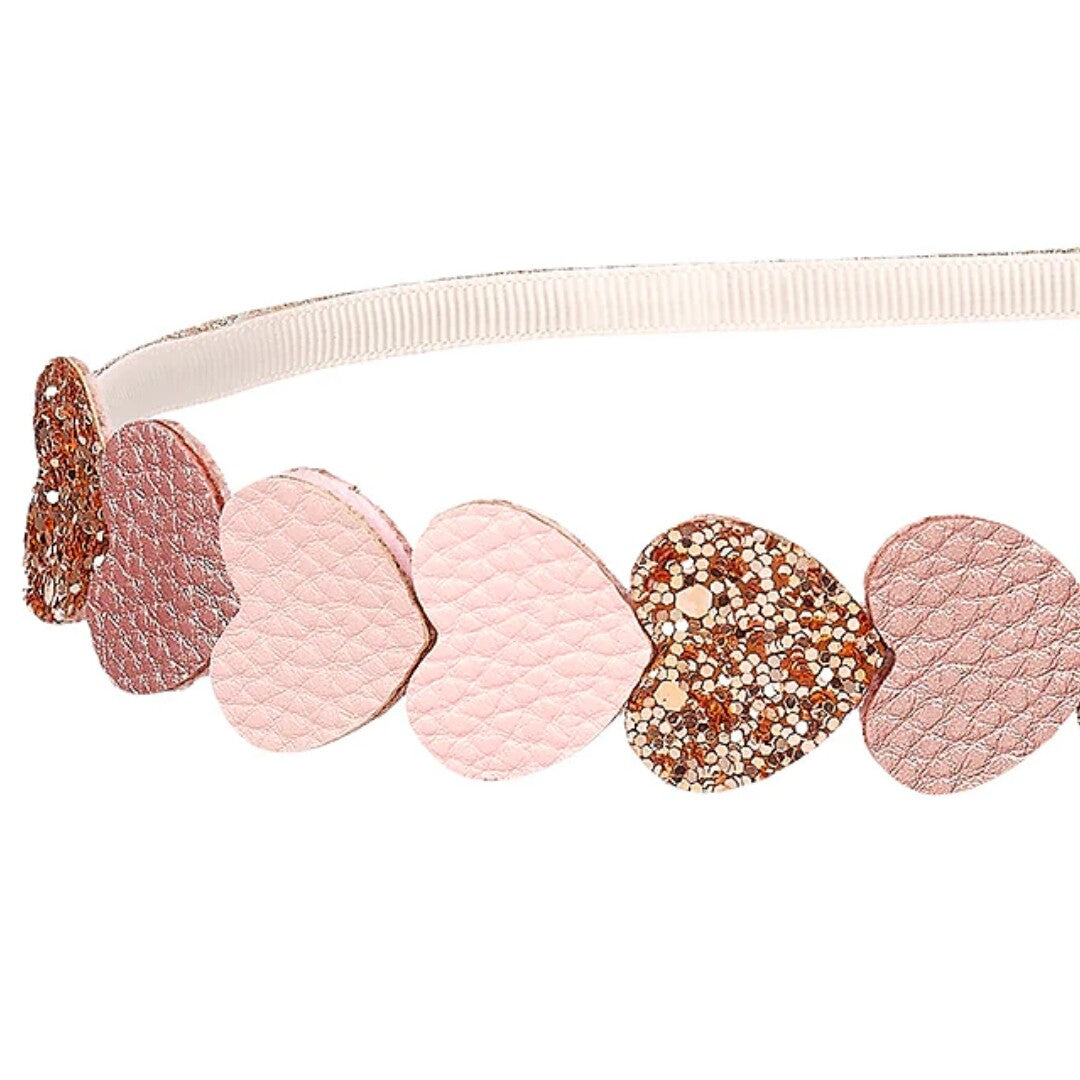 Detail van de kinder hoofdband met roze en glitterende harten.