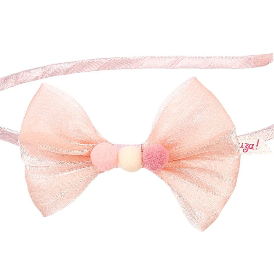 Detail van de Souza for Kids roze kinder hoofdband met strik en drie pompons.