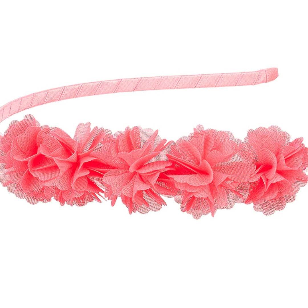 Detail van de roze kinder hoofdband met stoffen bloemen.