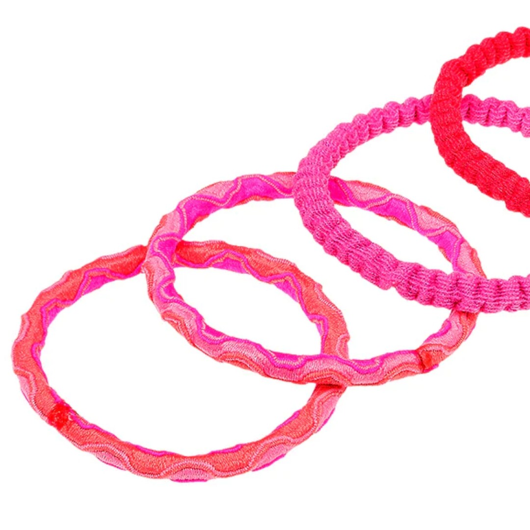 Detail van drie roze en rode haarelastiekjes met textuur.