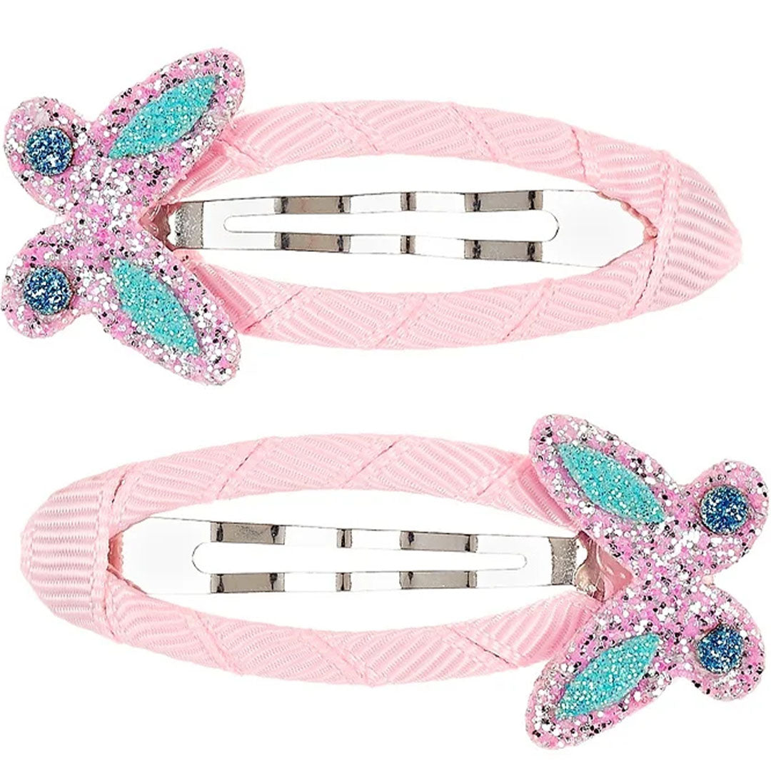 Twee roze souza for kids haarspeldjes voor kinderen, versierd met glitterende roze vlinders met blauwe accenten.