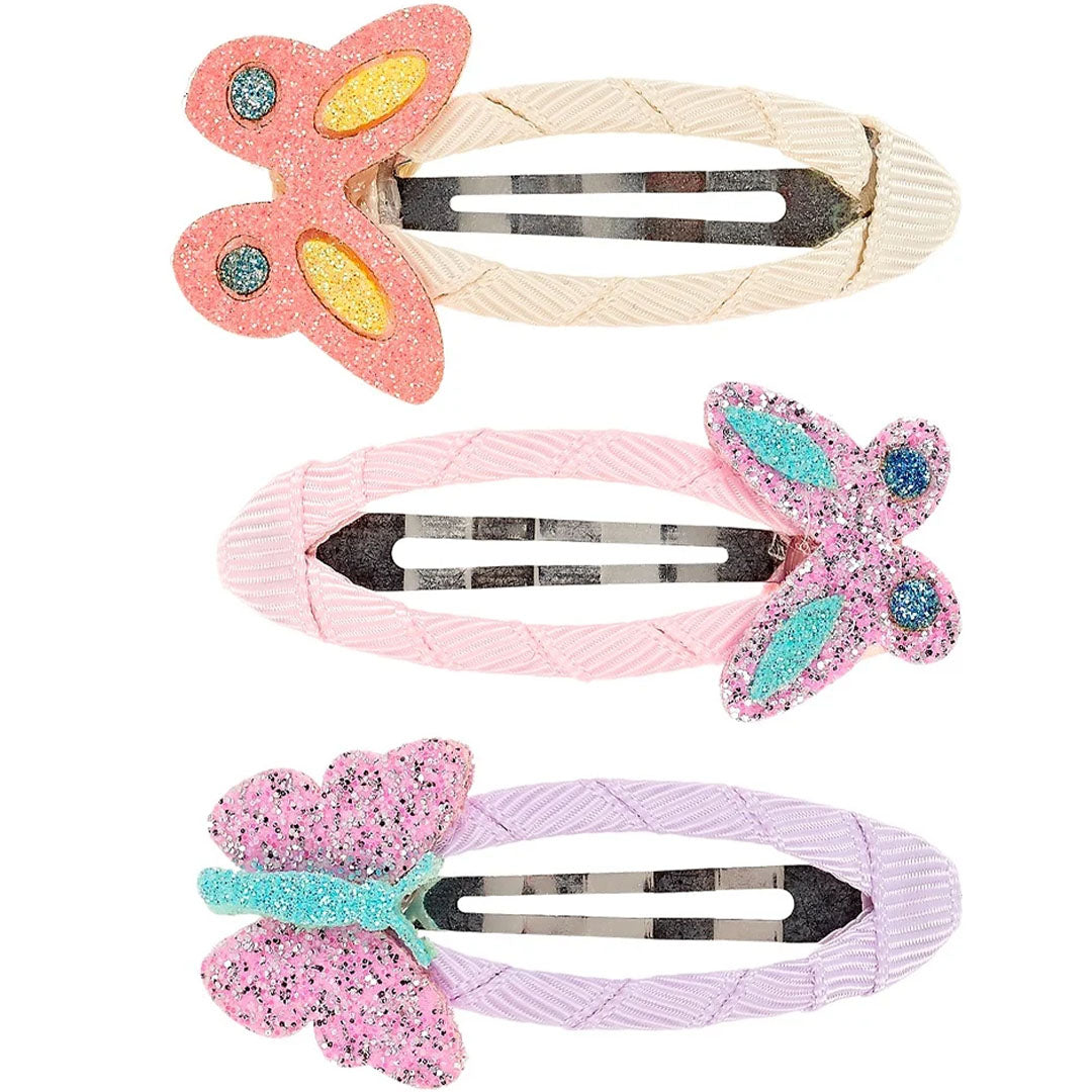 Drie souza for kids haarspeldjes met kleurrijke glitter vlinders op een beige, roze en paarse stoffen clip.