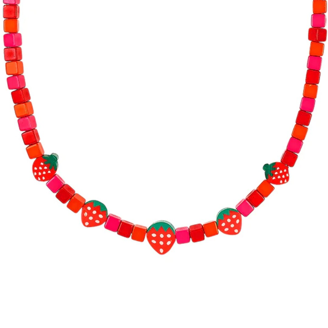 Detail van de kinder ketting met rode en roze kralen en aardbeienmotief.