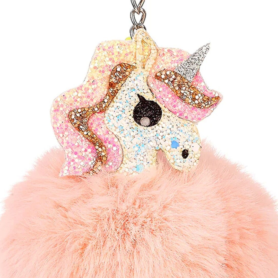 Detailopname van de glitter eenhoornkop op de roze pluizige sleutelhanger.