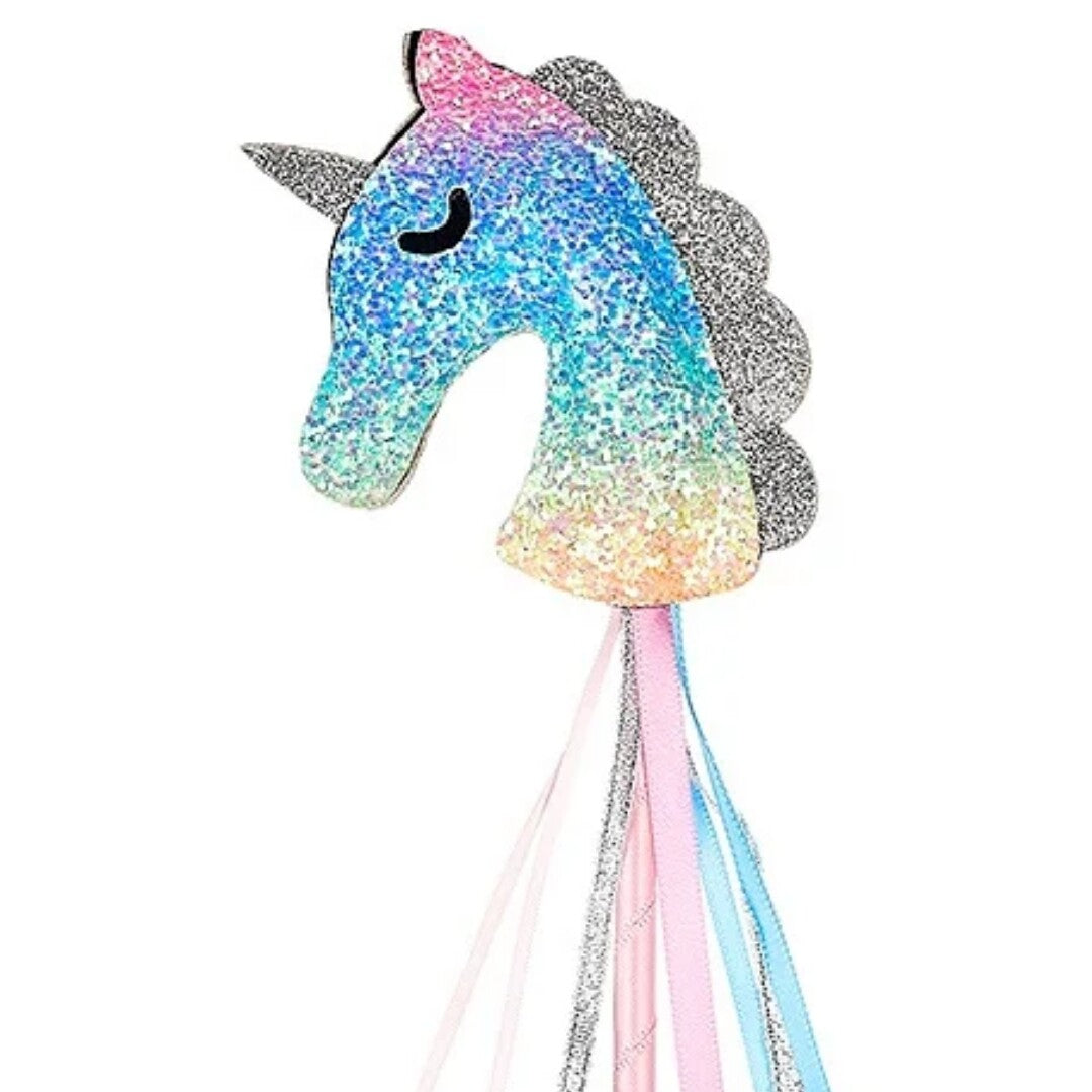 Detail van de glitter eenhoornkop van de toverstaf met regenboogkleuren en linten.