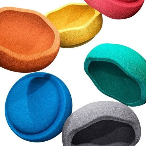 Een collectie Stapelstein speelelementen in verschillende kleuren, verspreid over een witte achtergrond.