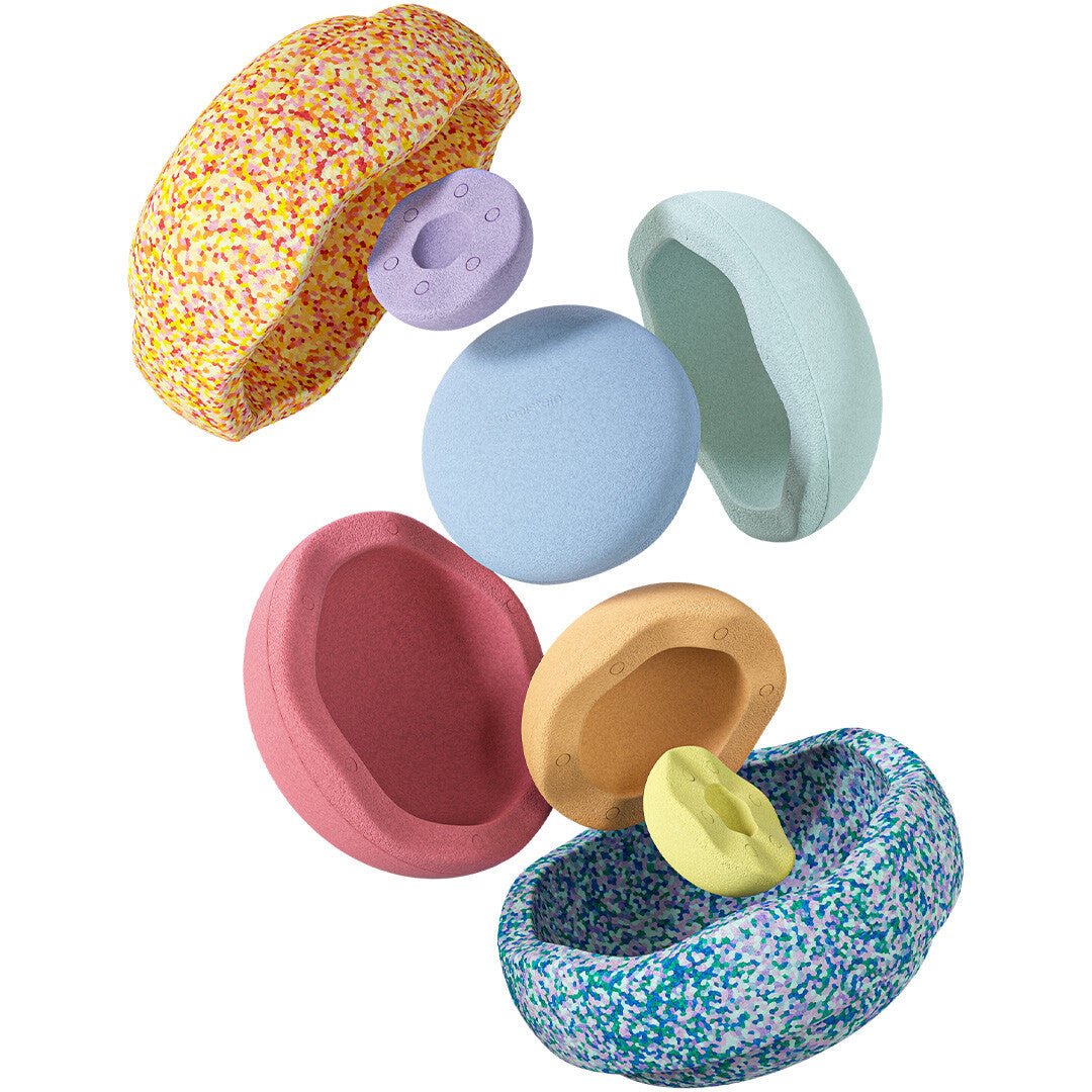 Diverse stapelstein stapelspeelgoed onderdelen in pastelkleuren zweven los van elkaar.