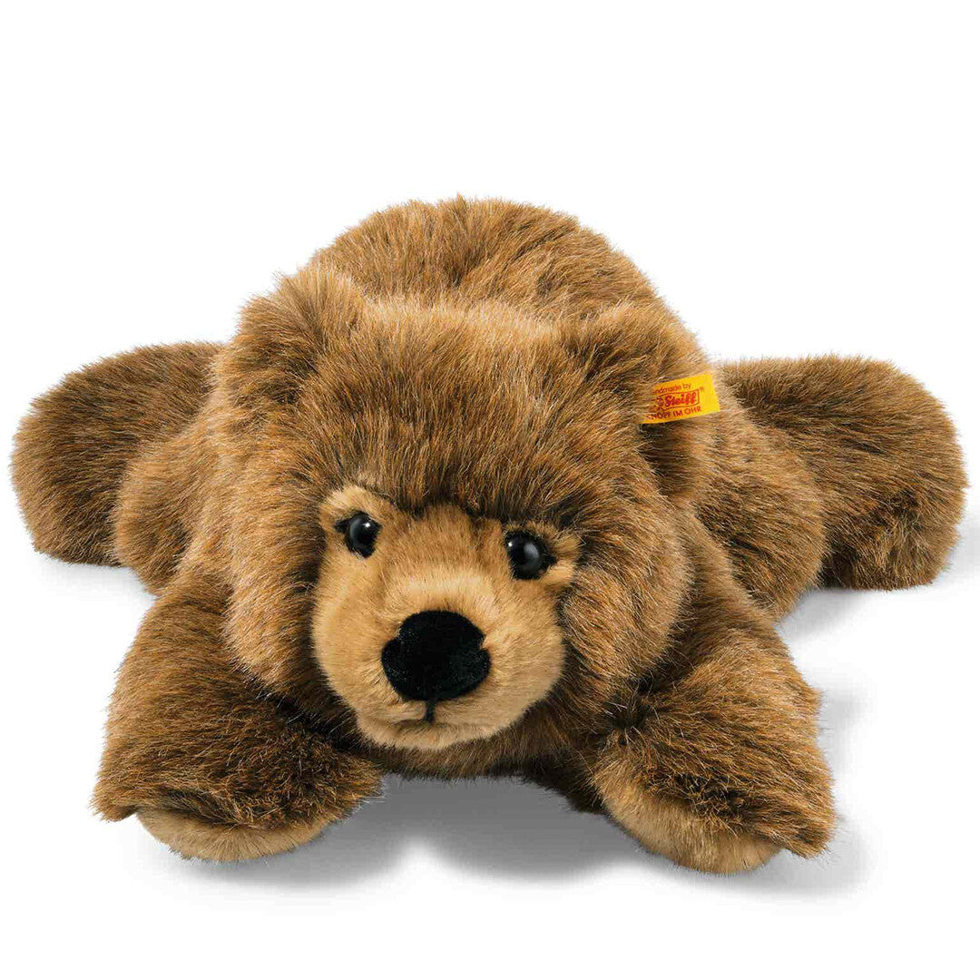 Steiff knuffel teddybeer Urs, bruin en liggend, van voren gefotografeerd.