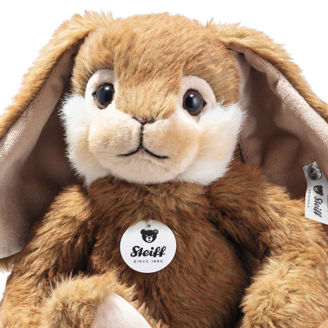 Detailfoto van het gezicht en de borst van een bruin Steiff pluchen konijn met merklabel.