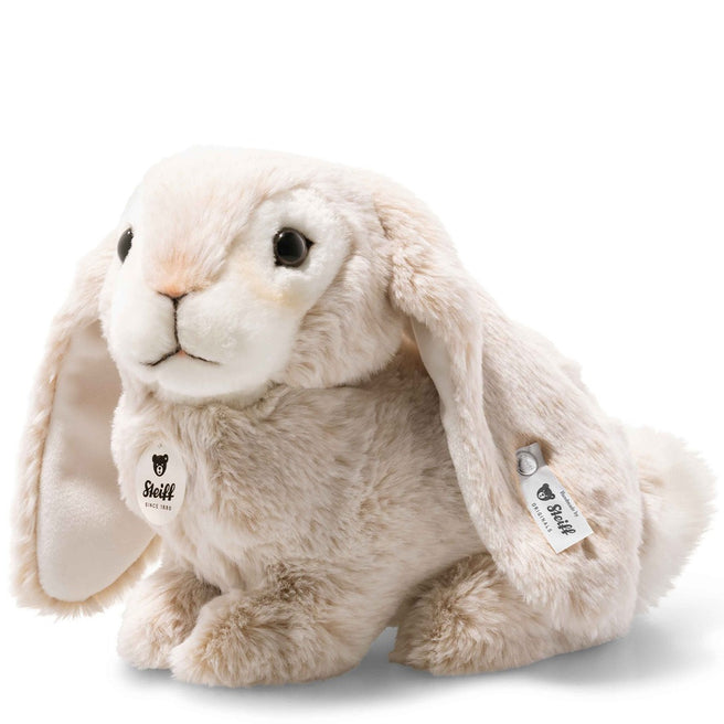 Steiff pluchen knuffelkonijn met beige vacht en hangoren, zittend op een witte achtergrond.