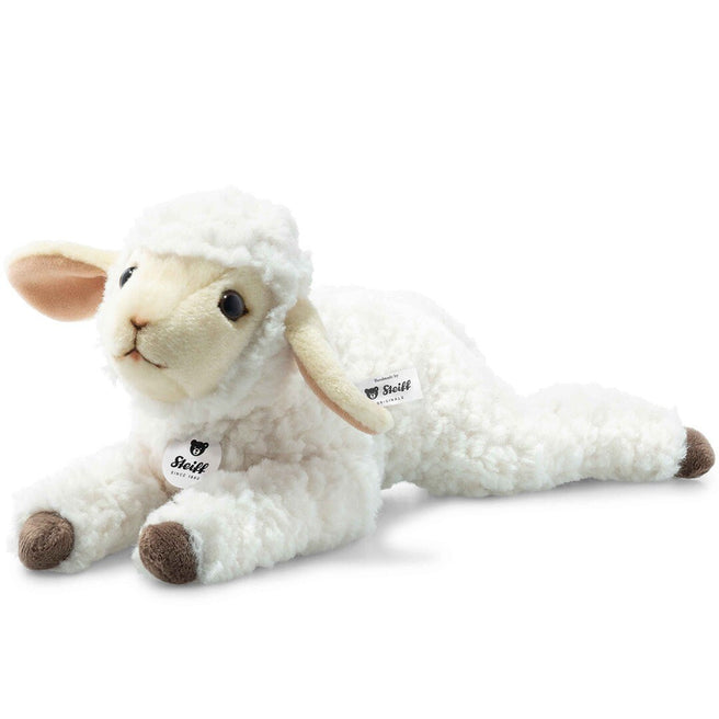 Steiff wit pluchen lammetje Boecky ligt op een witte ondergrond.