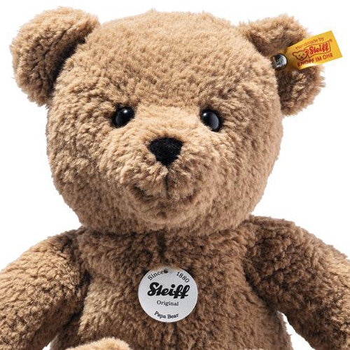 Close-up van de kop en borst van een bruine Steiff pluchen teddybeer met merklabel.