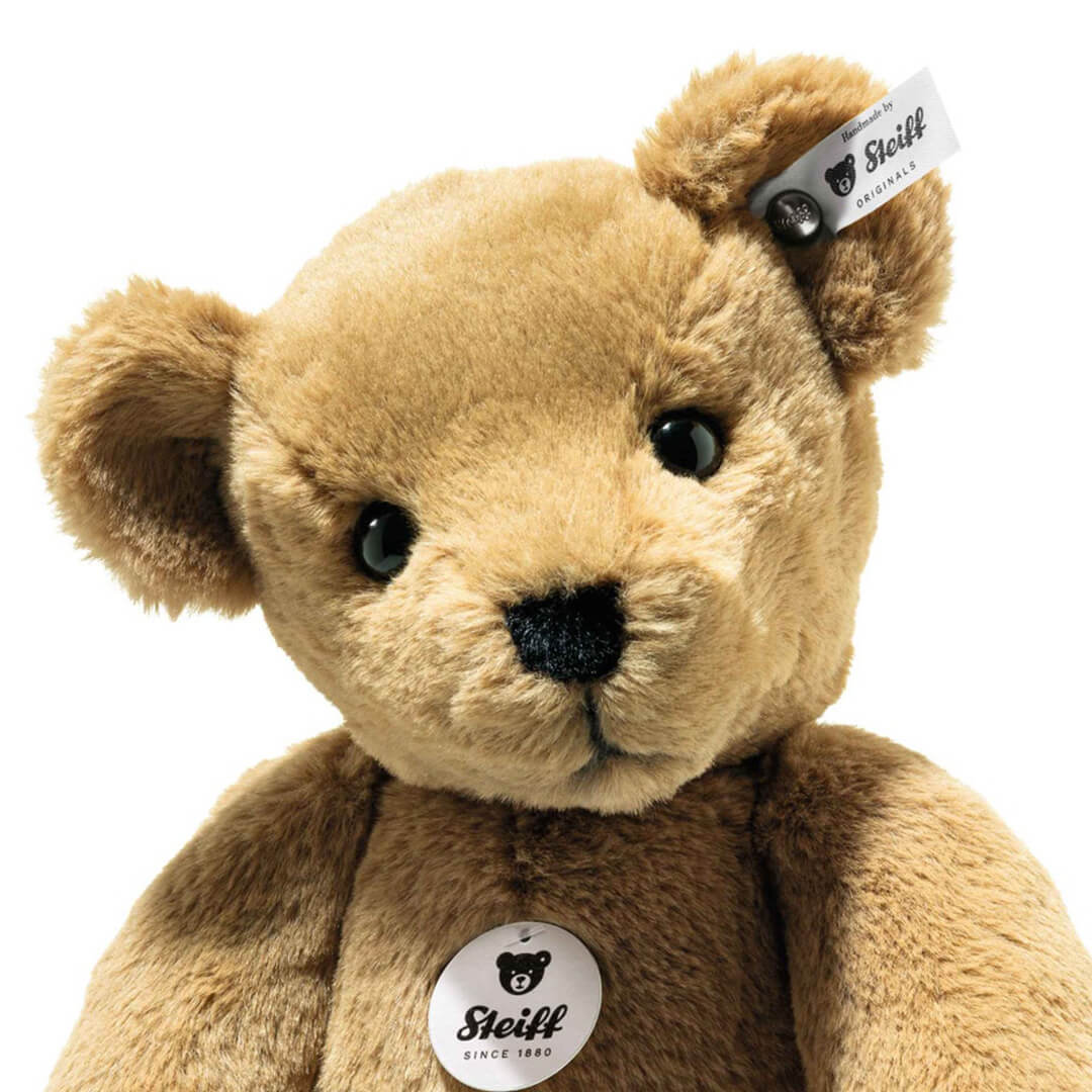 Detailopname van de kop en borst van de bruine Steiff pluchen teddybeer Lio.