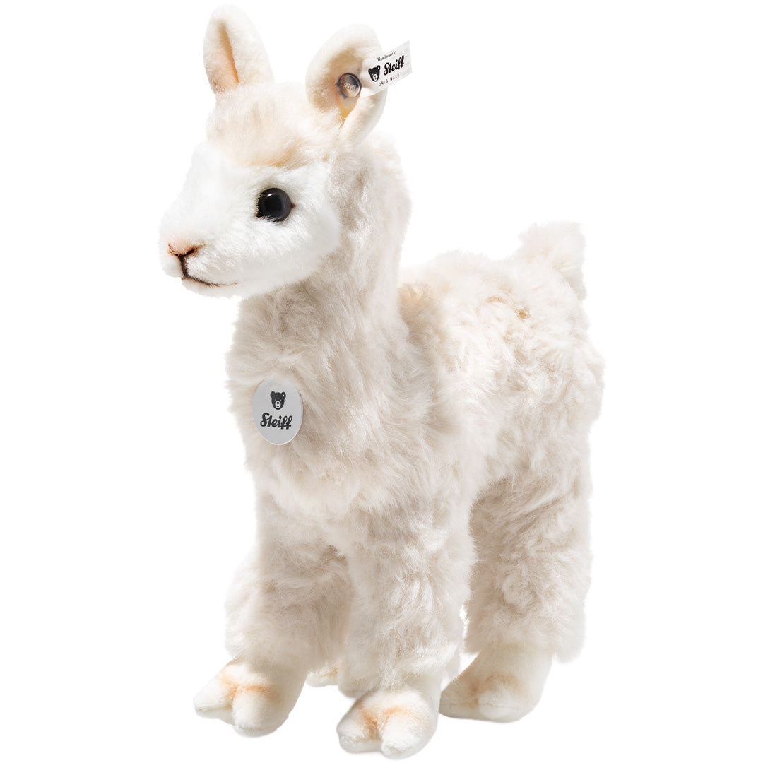 Steiff knuffelalpaca in crème kleur, staand en schuin van voren gefotografeerd.