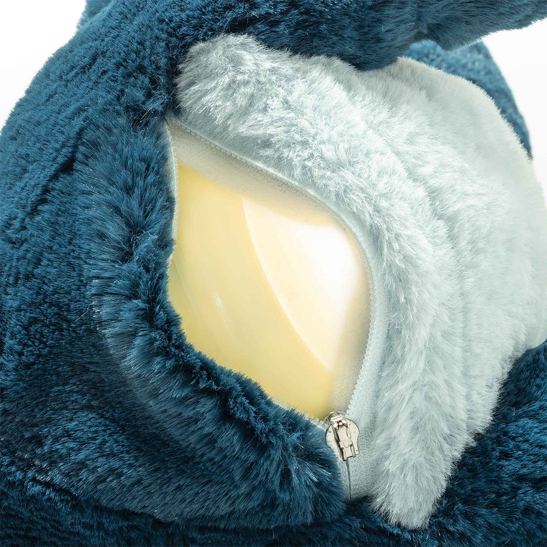 Detail van de Steiff knuffeldinosaurus Spott met open rits op de buik, waar een geel lichtelement zichtbaar is.