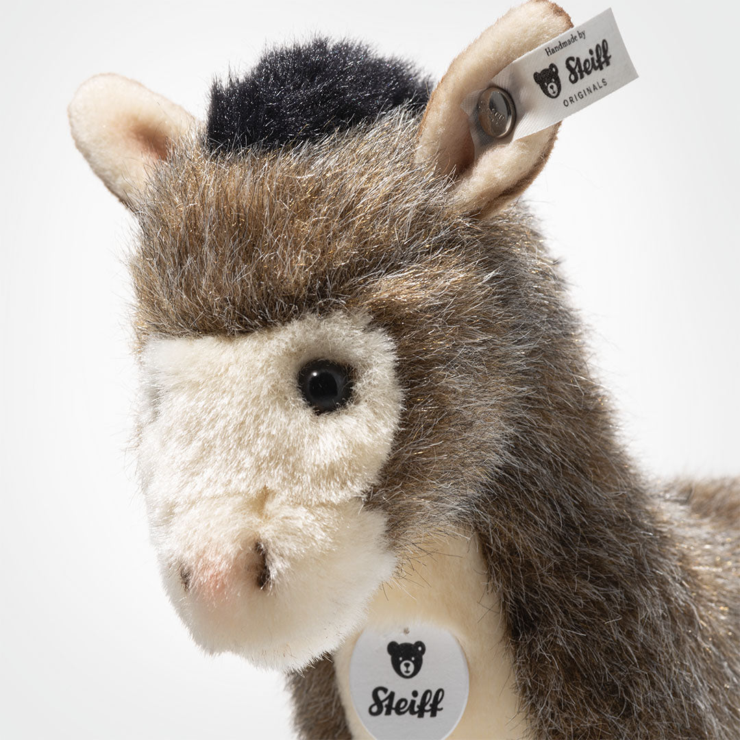 Detailfoto van de kop van de Steiff pluchen ezel Asinus met zichtbare merklabel.
