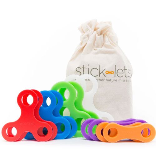 Een packshot van veelkleurige stick-lets siliconen connectors naast een katoenen opbergzak.