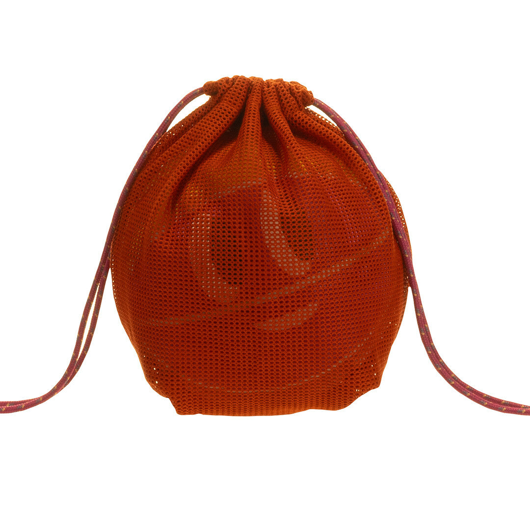 Een oranje nettas met trekkoord, met daarin de sticky lemon speelbal.