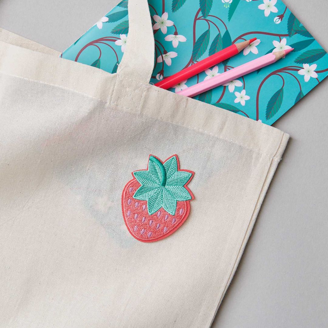 De aardbei strijkpatch is op een lichte stoffen tas gestreken.